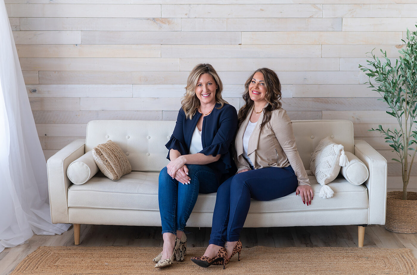 Beauty HQ co-owners Nicole Wente, RN and Melissa Pavelka seated together at the Lakeville clinic